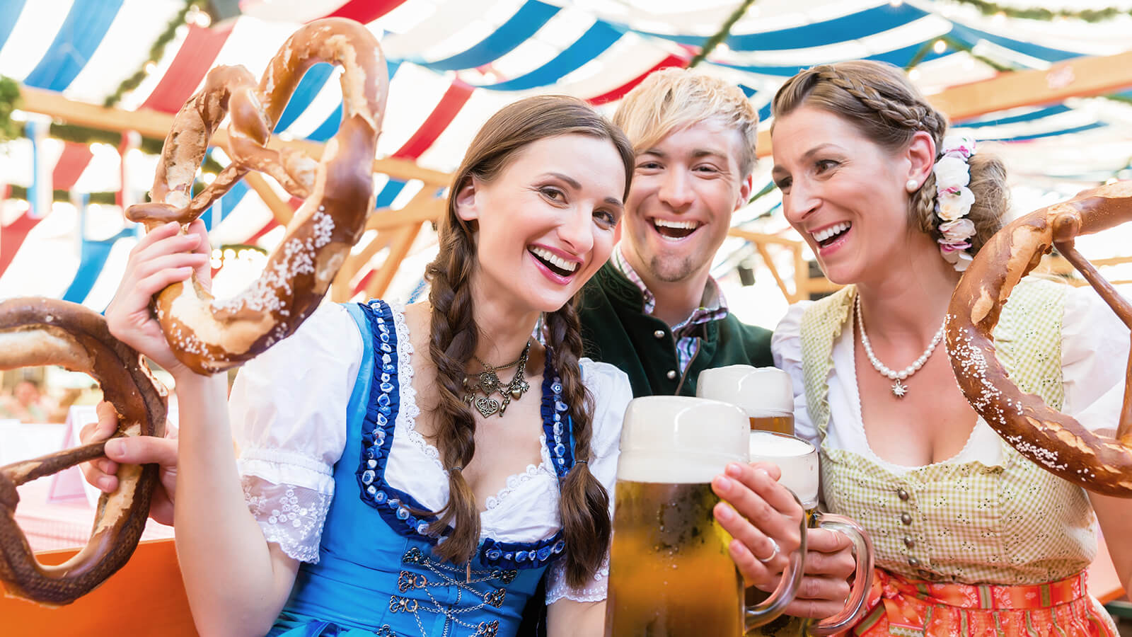 Friends with giant pretzels in Bavarian beer tent for nixplay oktoberfest promo